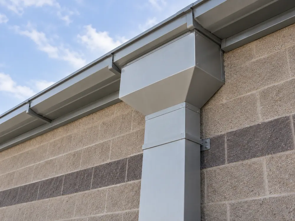 Large commercial gutter outlet connected to an exterior downspout