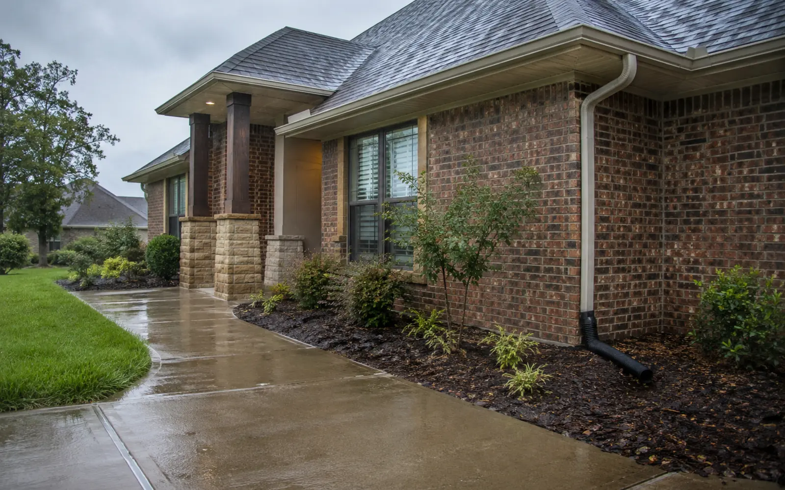Brick home with eavestrough and downspout after rainfall
